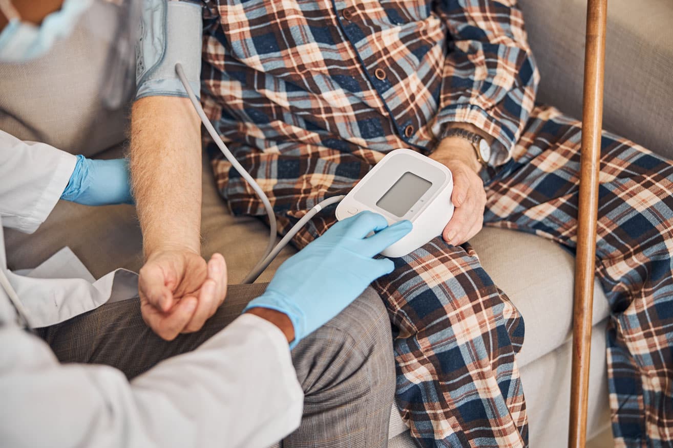 Image of a patient getting his blood pressure checked, for blog discussing what are the requirements to qualify for Medi-cal for hospice/health insurance for hospice.
